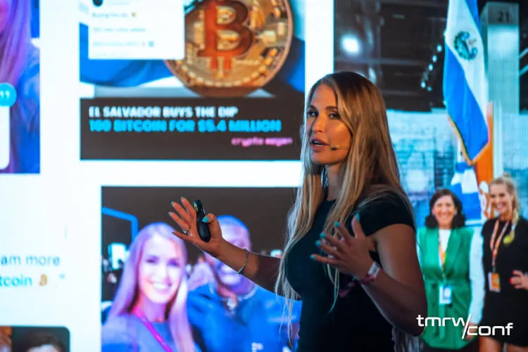 Speaker in front of a Bitcoin news slide
